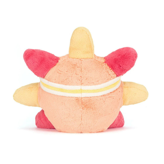 A plush toy character shown from the back, featuring a peach-colored body, bright pink ears and feet, and a yellow horn on top, with a white and yellow striped band around its waist, set against a plain white background.