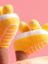 Yellow socks with white soles and decorative elements on a pink background