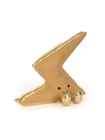 A small gold lightning-bolt-shaped plush toy with a smiling face and tiny feet, photographed on a clean white background.