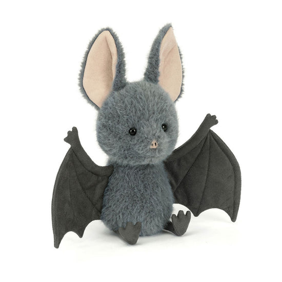 A plush toy bat in dark gray with large black wings, pink inner ears, and small black feet, photographed on a clean white background.