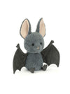 A plush toy bat in dark gray with large black wings, pink inner ears, and small black feet, photographed on a clean white background.