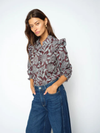 A woman modeling a long-sleeve button-up blouse with a gray and burgundy floral pattern, paired with high-waisted blue jeans, against a plain white studio background.