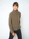 A woman modeling a olive fleece jacket with a mock neck and zippered front, paired with dark jeans, against a plain light gray background.
