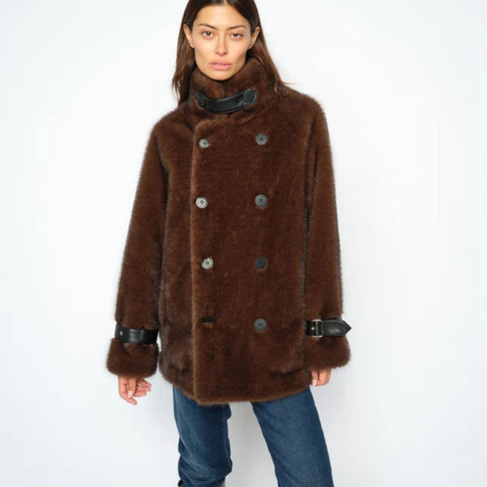 Person wearing a brown fur coat with a white background