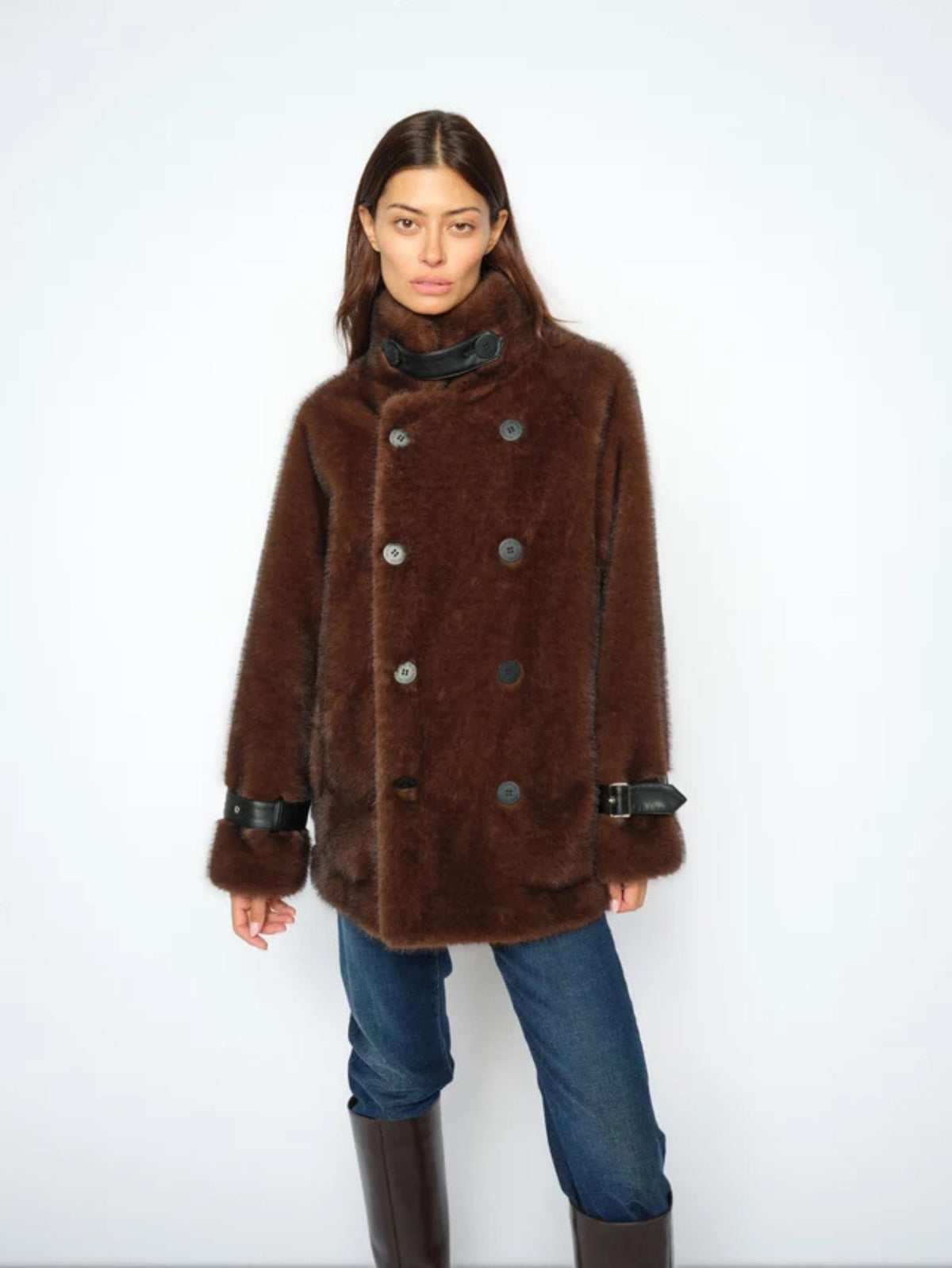Person wearing a brown fur coat with a white background