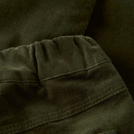 Close-up of dark olive green corduroy fabric showing the ribbed texture and stitched seam details.