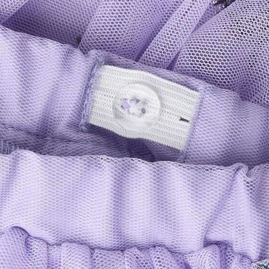 Close-up of a lavender purple mesh garment with a white button closure and ruffled trim.