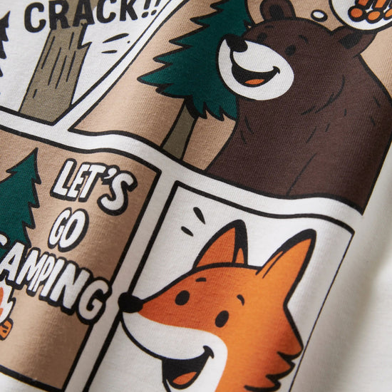 Close-up of a white T-shirt featuring a comic-style camping graphic with a brown bear, orange fox, tree, and text reading 'CRACK!!' and 'LET'S GO CAMPING'.