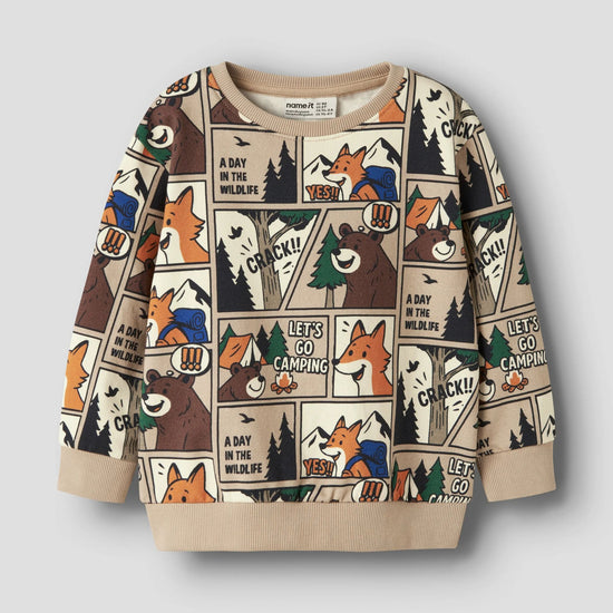 A children's long-sleeve crewneck sweatshirt featuring a colorful cartoon animal comic strip print on a beige background, with solid beige ribbed cuffs and hem, shown against a light gray background.
