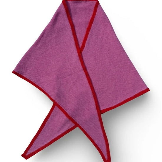A folded Pink Triangular Scarf with red trim, arranged in a crossed pattern on a white background.