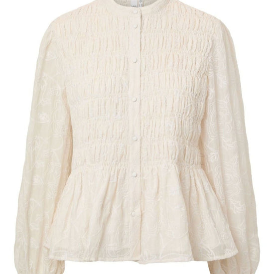 An off-white textured blouse with long balloon sleeves, a smocked bodice, and a peplum hem, shown against a plain white background.