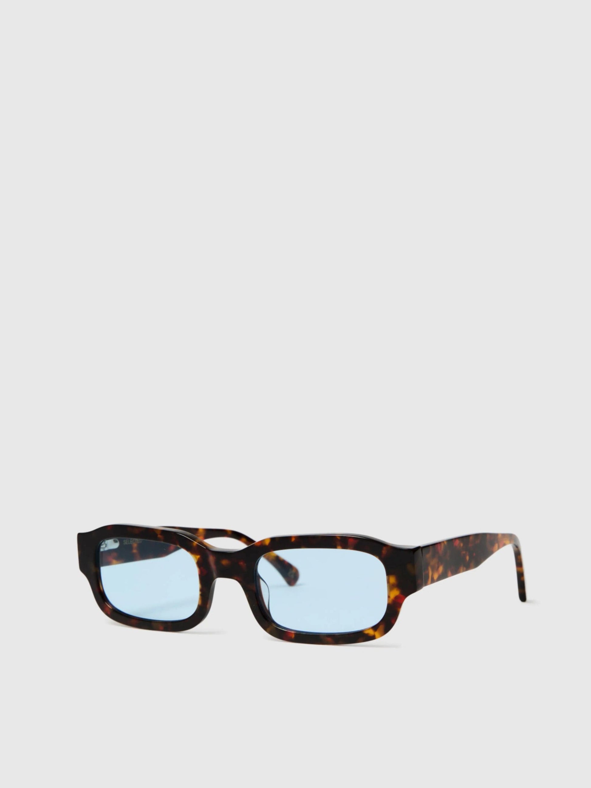 Sunglasses with tortoiseshell frame and blue lenses on a white background