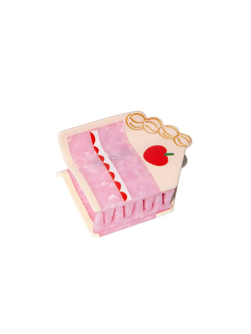 Pink cake-shaped hair clip with cherry detail on a white background