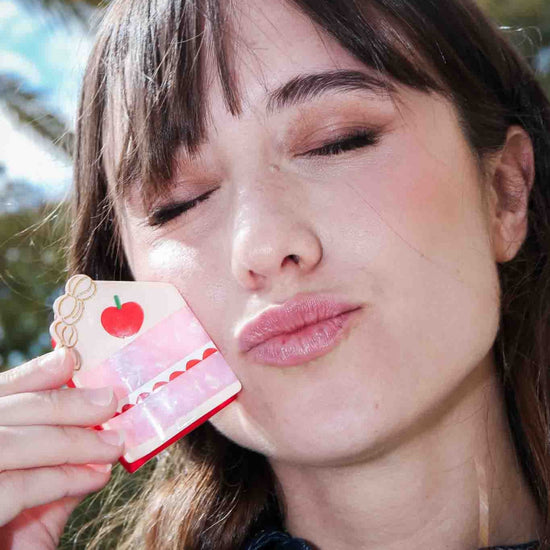 Woman holding a cake shaped hair clip 