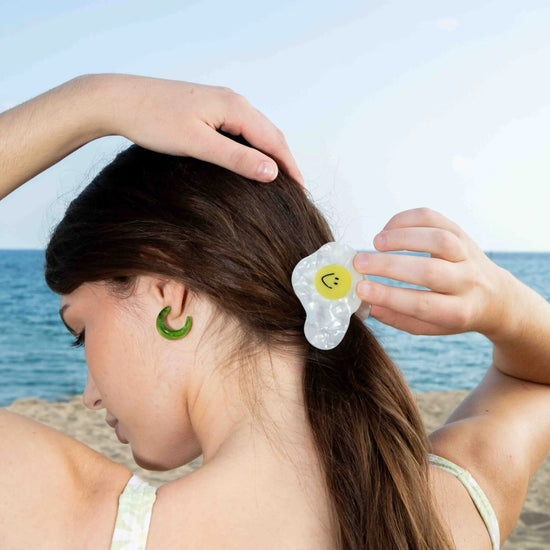 Person at the beach with fried egg shaped hair clip