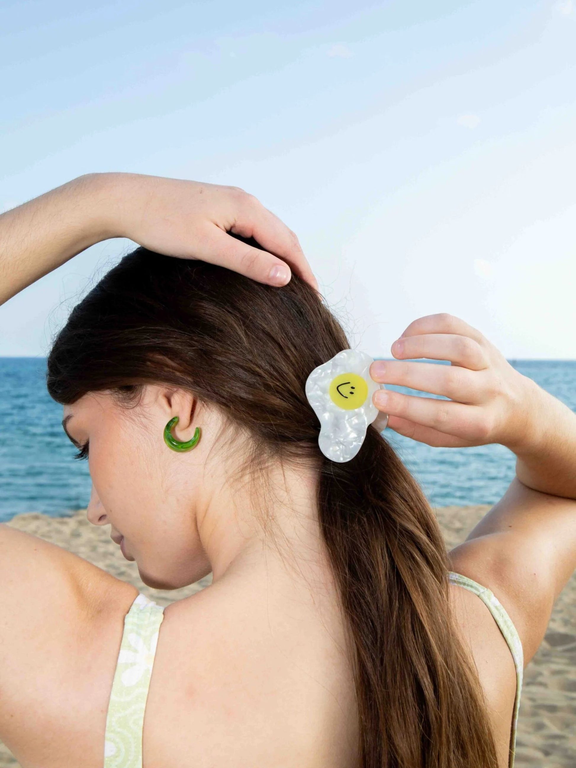 Person at the beach with fried egg shaped hair clip