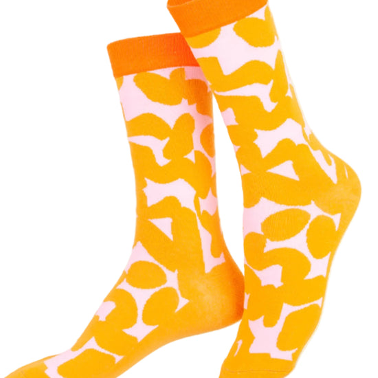 Colorful socks with orange tops and yellow and pink pattern on a white background