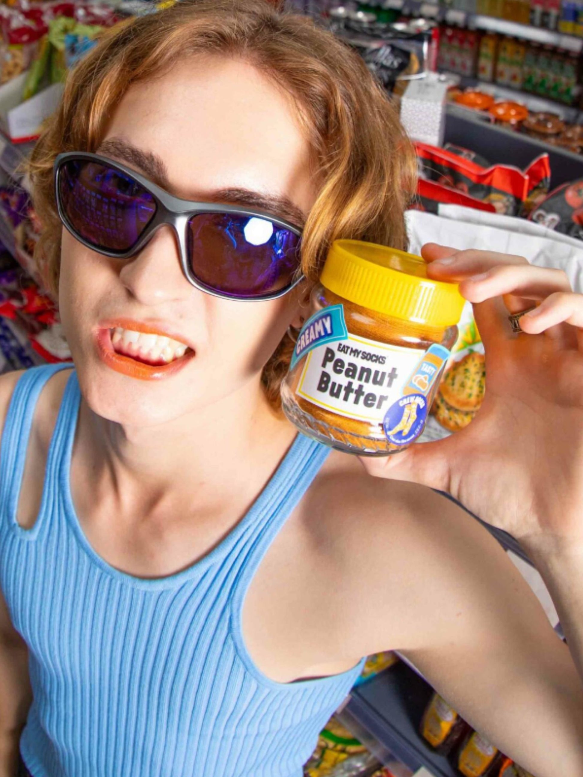 Person holding a jar of socks that look like peanut butter in a store setting