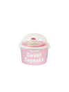 Pink cupcake-shaped container with a pair of pink and white socks inside on a white background