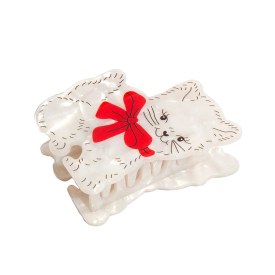 Cat-shaped hair clip with a red bow on a white background