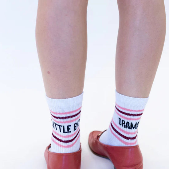 White socks with red and black text worn with red shoes on a white background