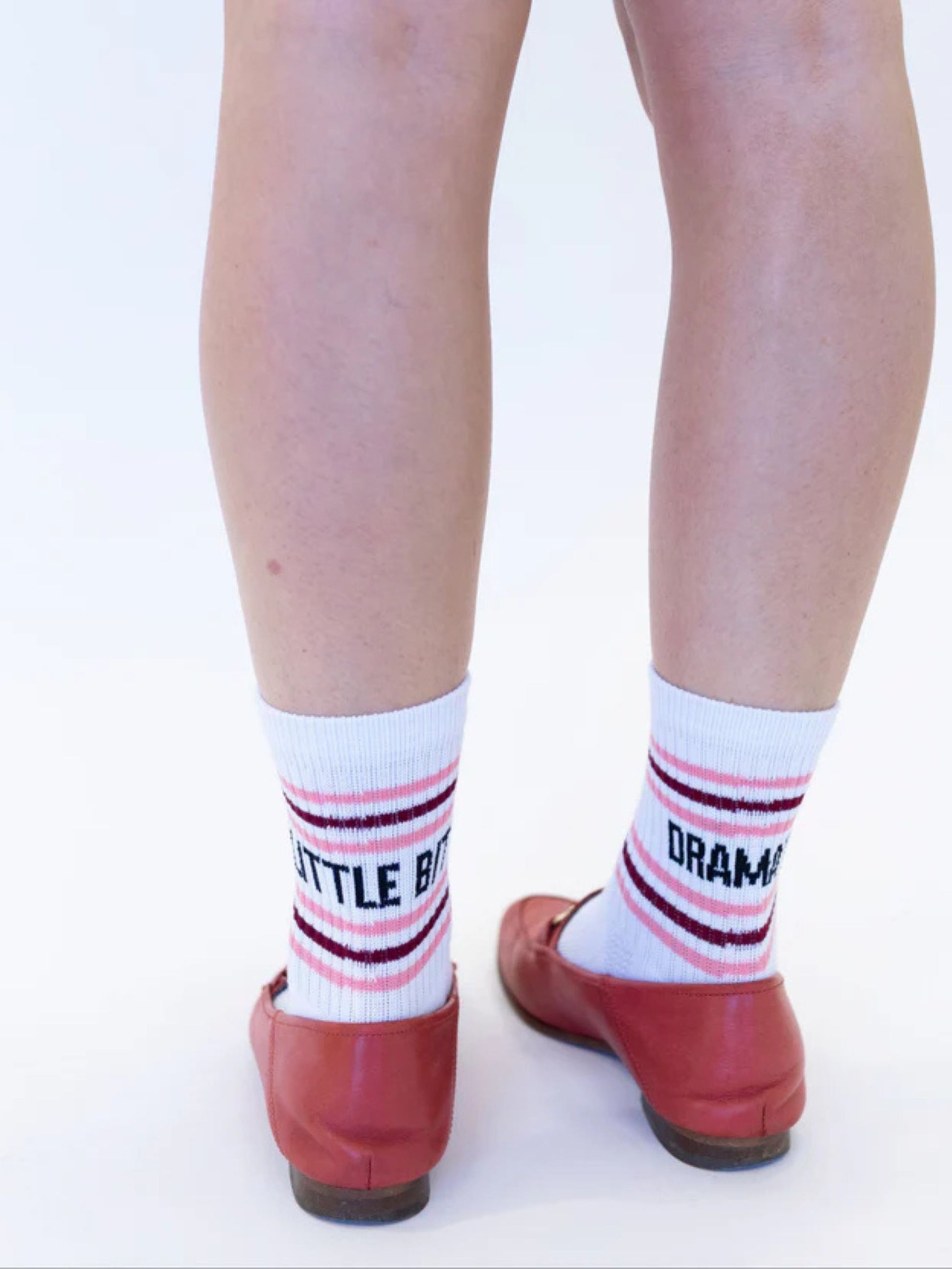 White socks with red and black text worn with red shoes on a white background