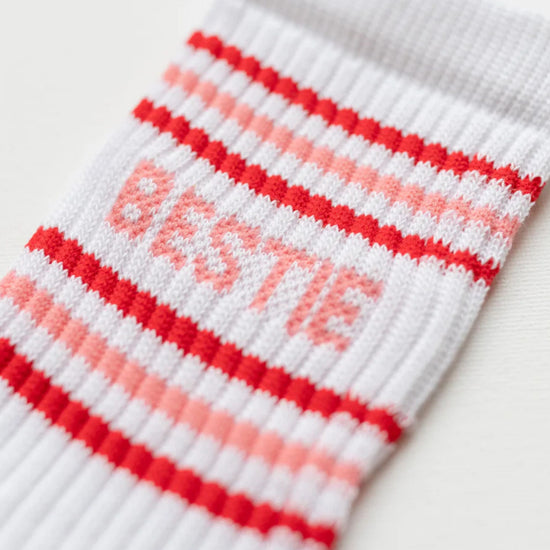 White sock with red and pink stripes and the word 'Bestie' on a white background
