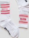 White socks with red and pink stripes and 'BESTIE' text on a light background