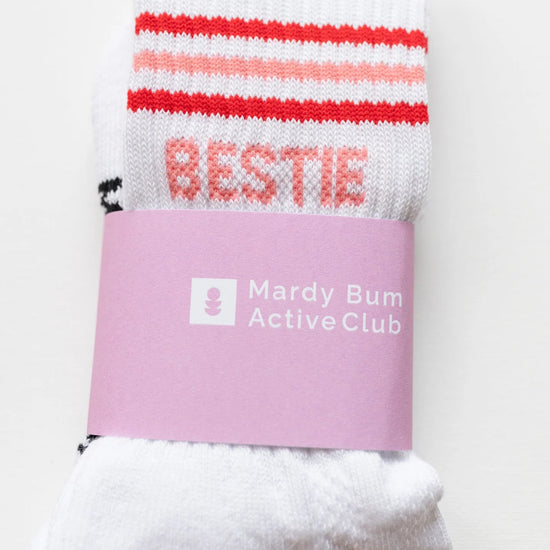 White socks with red and pink stripes and a pink band labeled 'Mardy Bum Active Club' on a white background.