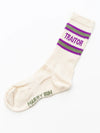 White sock with purple and green striped cuff and 'Traitor' text on a white background