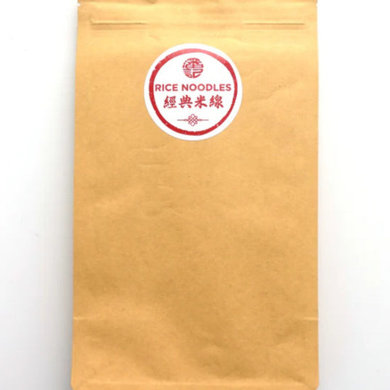 A kraft paper stand-up pouch with a circular red and white label reading 'RICE NOODLES' and Chinese characters, photographed on a plain white background.