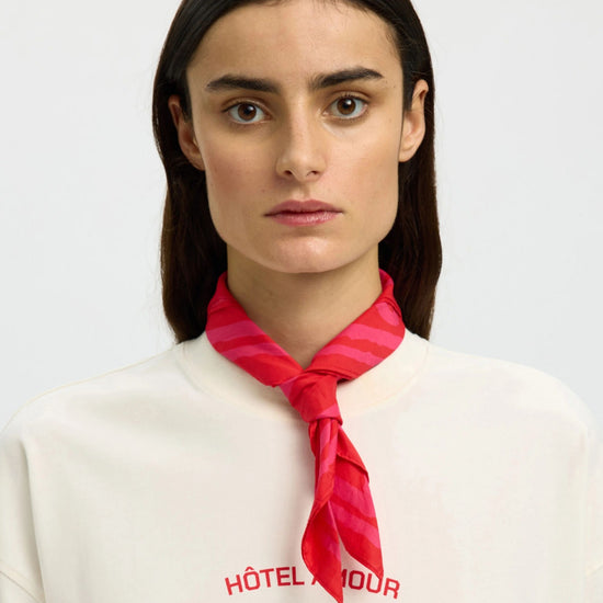 Woman wearing a red neck scarf on a white background