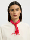 Woman wearing a red neck scarf on a white background