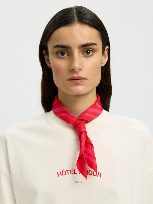 Woman wearing a red neck scarf on a white background