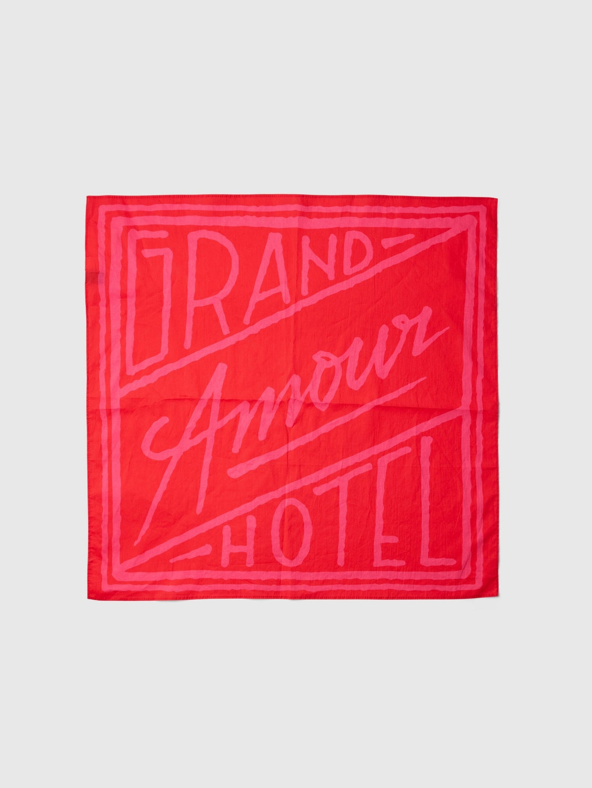 Red bandana with 'Grand Amour Hotel' text on a white background