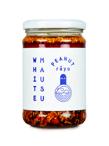 A glass jar of White Mausu Peanut Răyu chili oil with visible red chili peppers and seeds suspended in the reddish-brown oil, sealed with a white lid and featuring a white label with blue text and logo.